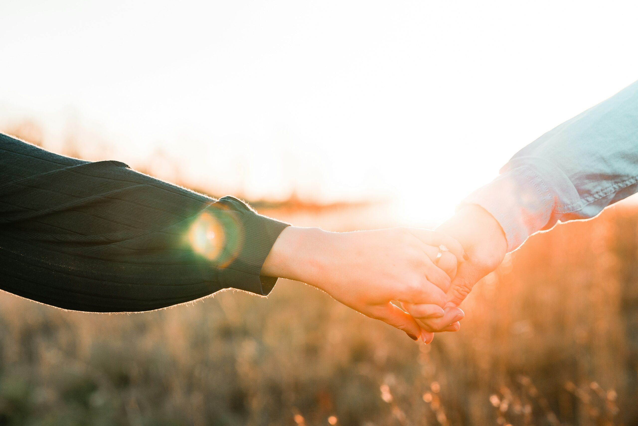 Two hands holding in the sunglight